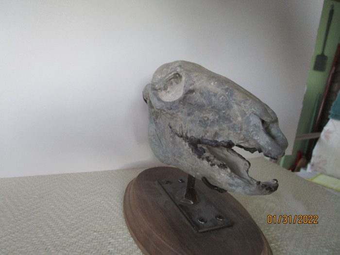 A bird statue sitting on top of a wooden base.