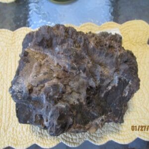 A piece of chocolate cake on top of a yellow paper.