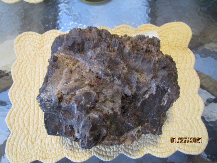 A piece of chocolate cake on top of a yellow paper.