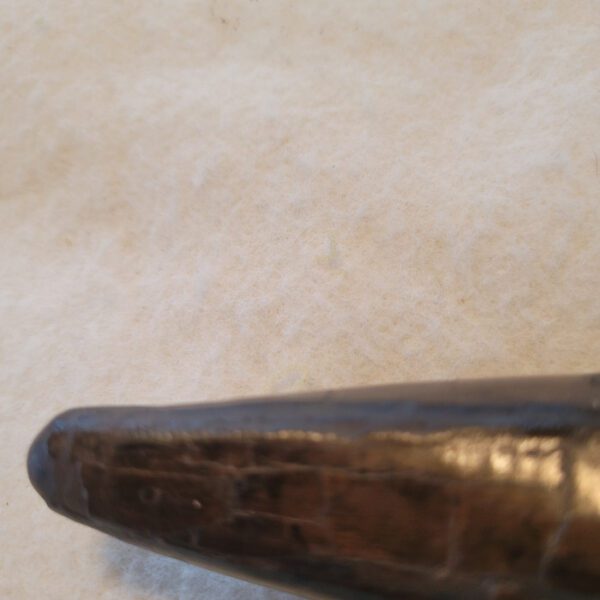 A close up of the tip of an old baseball bat.