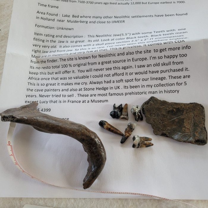 A piece of metal and some nails on top of paper.